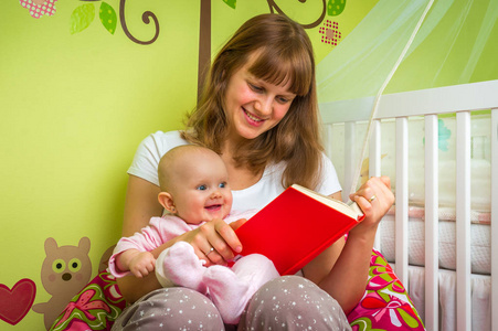 微笑的母亲和她的孩子读一本书图片