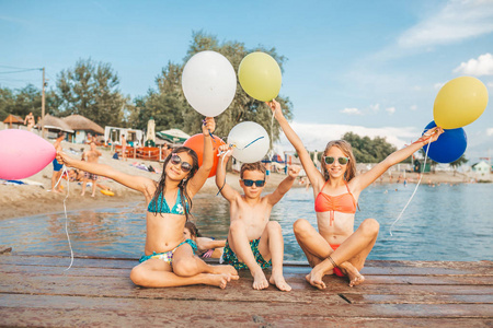 快乐的孩子们在海里玩气球。孩子们在户外玩得很开心。暑假和健康的生活方式概念