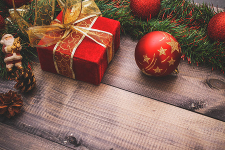 新年的装饰和节日玩具在一张木桌上, 上面有一个红色的弦盒, 上面有圣诞老人的礼物