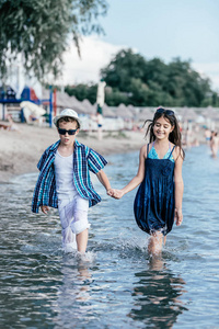 快乐的孩子们在海里玩。孩子们在户外玩得开心。暑假和健康的生活方式的概念