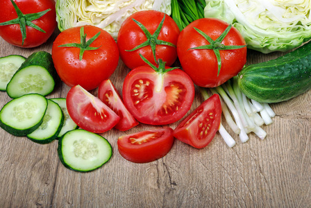 新鲜成熟的蔬菜西红柿, 卷心菜, 葱和黄瓜在木桌上