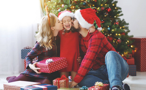 幸福的家庭父母和孩子女儿打开礼物在圣诞节早晨