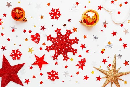 圣诞节和新年假期的背景与装饰。闪亮的金球, 红色雪花和星形五彩纸屑。平面布局, 顶部视图