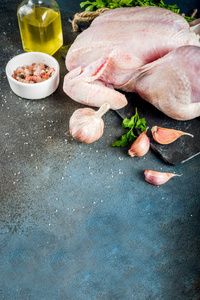烹饪鸡的背景与生整只鸡, 草药和香料, 深蓝色混凝土桌子复制空间顶部视图