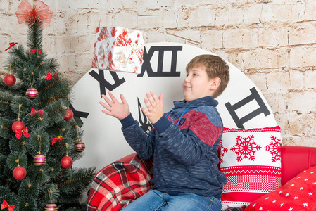 十几岁的男孩在圣诞树和其他装饰物的背景上，对待礼品