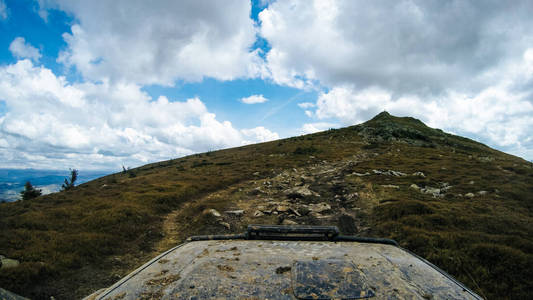 乘汽车旅行在乌克兰喀尔巴阡山脉。兜帽车和山景。越野