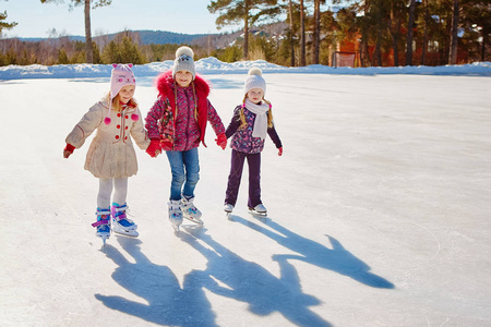 三个小女孩的朋友学会了滑冰。户外娱乐和度假