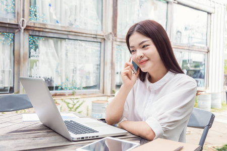 年轻快乐休闲亚洲女人与她的笔记本电脑使用技术