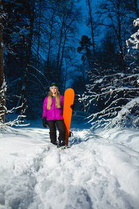 年轻的女人，与她在黑暗的冬季森林的滑雪板