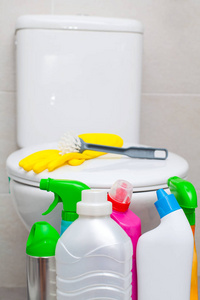 五颜六色的浴室清洁用品和黄色橡胶手套, 白色厕所平底锅的背景