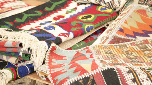美丽的手工地毯，在公开市场商场上的一堆。土耳其的传统设计