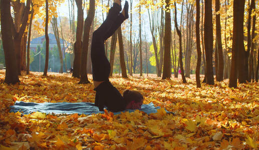在公园做瑜伽健身操的年轻有吸引力的妇女