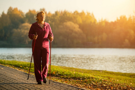 芬兰的体育越野行走。高级妇女徒步旅行在森林或公园。积极健康的生活方式