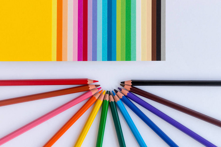 彩色的铅笔和白色背景的彩色的纸