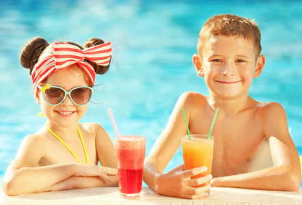 阳光明媚的日子, 小孩子在游泳池里喝鸡尾酒