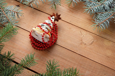 圣诞树, 用奶酪做成红色装饰, 放在木板上。云杉分枝在木背景。用奶酪和子做成的冷杉树。节日模式, 顶视图