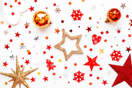 圣诞节和新年假期的背景与装饰。闪亮的红球, 金色的雪花和星状的五彩纸屑。平面布局, 顶部视图