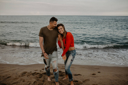 幸福的夫妇在海滩上散步的爱