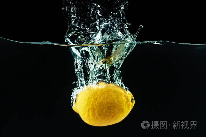 新鲜的黄色柠檬掉进水里, 溅起水花