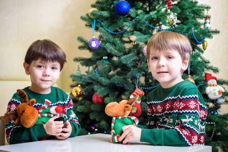 愉快的孩子在家或幼稚园在新年树背景戏剧与圣诞节麋鹿