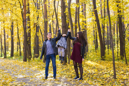 人, 家庭和休闲概念愉快的家庭与女儿在秋天公园散步