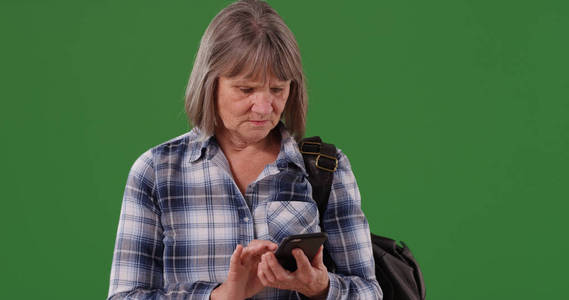 失去了老白种人女性用手机在绿色屏幕上获得方向