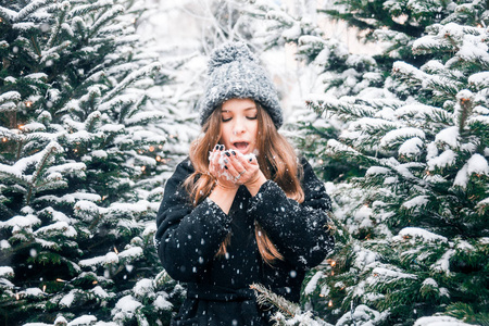 美丽的俄罗斯女孩吹在雪在圣诞节时间在茨维尔斯卡亚广场