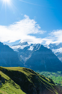 格林德沃村庄与阿尔卑斯山和蓝色天空在瑞士