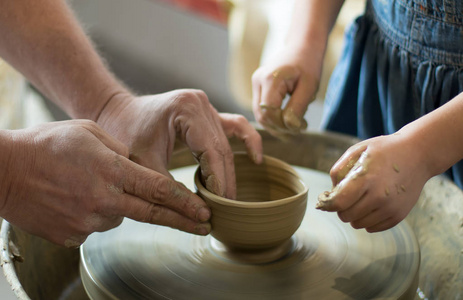 密切起来的成熟波特手的指南和帮助一个孩子让粘土锅上窑匠，大师班或团队合作的概念。Selectiva 焦点