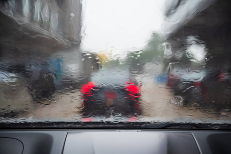 大雨。车窗上的雨滴。抽象模糊的交通和汽车灯光。大雨和背光造成的视力不佳