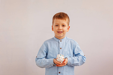 可爱的小男孩抱着一个储钱罐或存钱罐