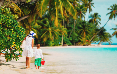 母亲和儿子在热带海滩上行走