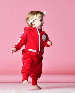 婴儿男婴幼儿在红色的身体布使第一步快乐笑在浅粉色