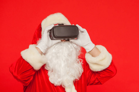 圣诞老人戴着虚拟现实护目镜, 在红色的背景