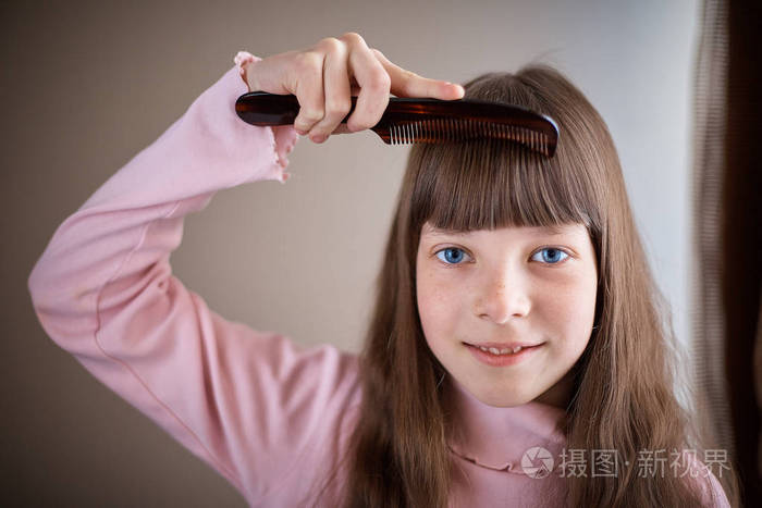 有雀斑和蓝眼睛梳头的小女孩梳头