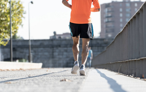 关闭强大的运动腿与撕裂的小腿肌肉的运动男子跑在日落与复制空间在城市城市训练运动健身锻炼马拉松和健康生活方式的概念