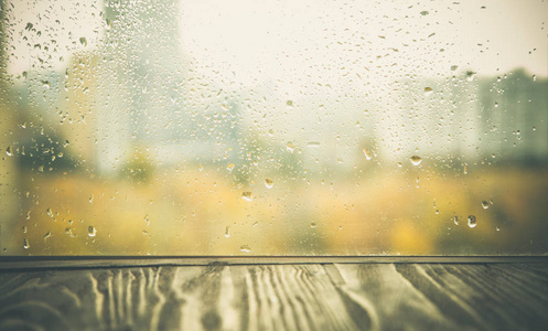 秋天背景木桌在雨窗口前面