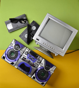复古媒体技术。娱乐80年代。黑色白色灯电视, 录音机, 录像带, 3d 眼镜上的绿色柔和黄色背景。顶部视图。扁平