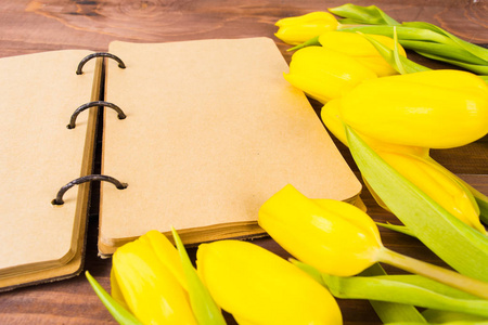 打开老式笔记本或日记和黄色郁金香