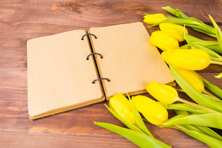 打开老式笔记本或日记和黄色郁金香