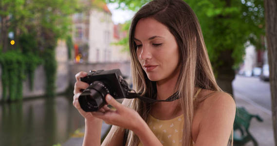 愉快的高加索妇女与相机拍照, 同时探索布鲁日市