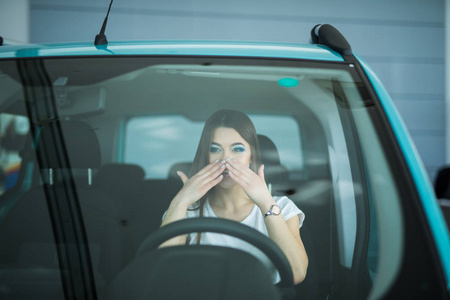 美丽的女人开的车，手放在嘴里震惊