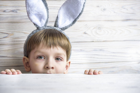 孩子在桌子下偷看等待复活节兔子的兔子耳朵