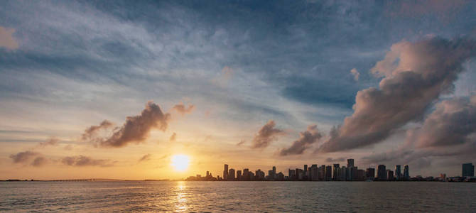从海下的天空和云在日落, 在佛罗里达州, 美国迈阿密市中心的天际线视图