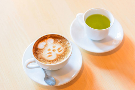 桌上的热腾腾的卡布奇诺咖啡和绿茶