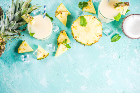 清爽的夏日饮品, 自制的飘香鸡尾酒, 在浅蓝色的背景下, 用菠萝椰子冰和薄荷叶片, 复制空间顶端视图
