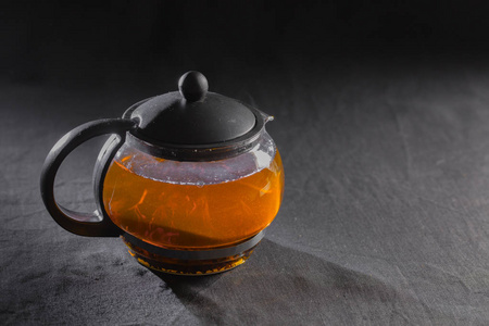 在黑色背景上的透明茶壶红茶