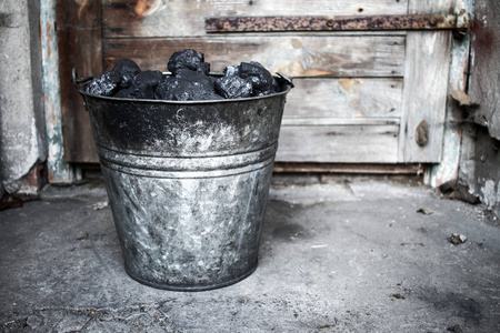 黑炭，老又脏又臭的金属桶中的碳