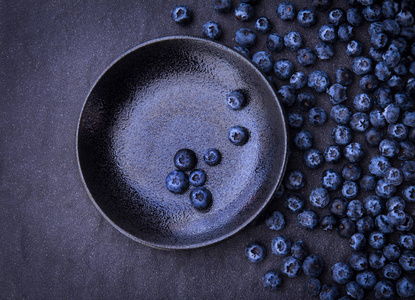 黑色的石头背景上新鲜采摘的蓝莓