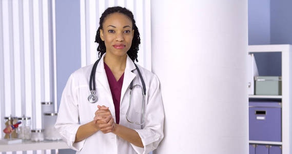 友好的黑人女医生站在办公室